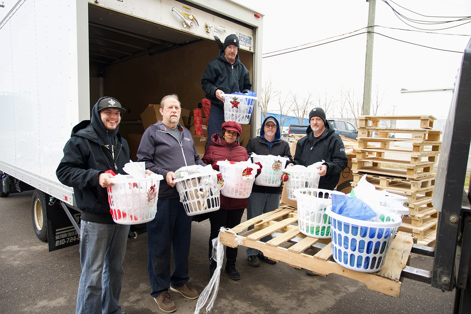 Phoenix Innovate team members load gifts for the Adopt a Family program into a truck for delivery.